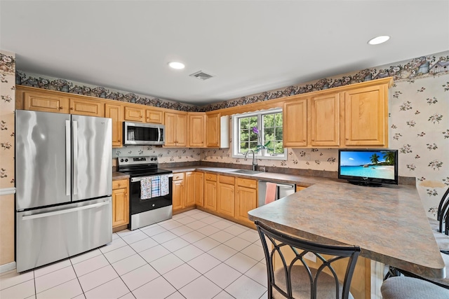 33 Sutherland Dr, Highland Mills, NY 10930 - kitchen featuring appliances with stainless steel finishes, wallpapered walls, a sink, a peninsula, and dark countertops
