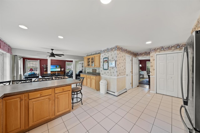 33 Sutherland Dr, Highland Mills, NY 10930 - kitchen featuring freestanding refrigerator, wallpapered walls, a kitchen bar, ceiling fan, and a baseboard heating unit