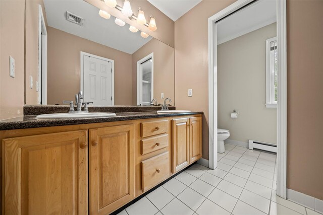 33 Sutherland Dr, Highland Mills, NY 10930 - full bathroom featuring a baseboard heating unit, toilet, double vanity, and tile patterned flooring