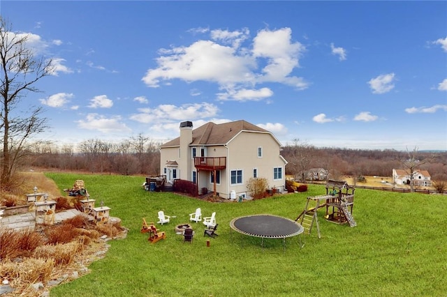11 Dorian Way, Campbell Hall, NY 10916 - back of property with a trampoline, a yard, a balcony, and an outdoor fire pit
