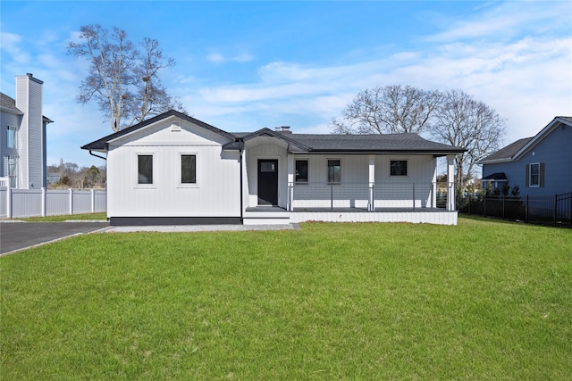 view of front facade featuring a front yard and fence