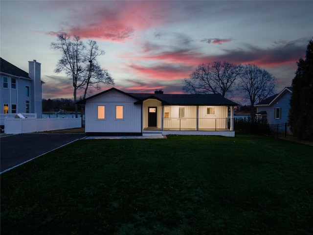 view of front of home featuring fence and a yard
