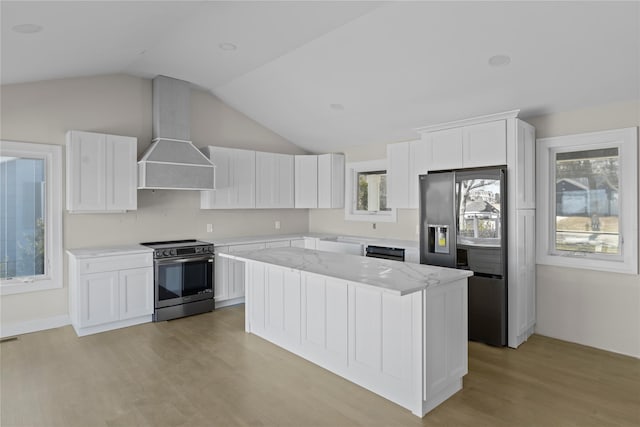 kitchen featuring light wood-type flooring, premium range hood, a center island, white cabinets, and appliances with stainless steel finishes
