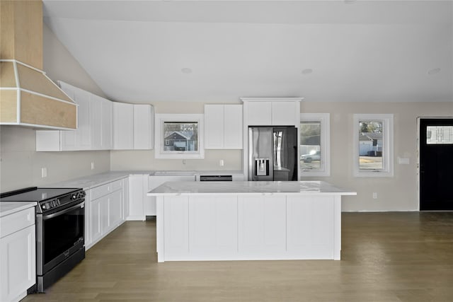 kitchen with wood finished floors, wall chimney exhaust hood, stainless steel range with electric cooktop, a kitchen island, and fridge with ice dispenser