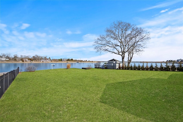 view of yard with a water view and fence