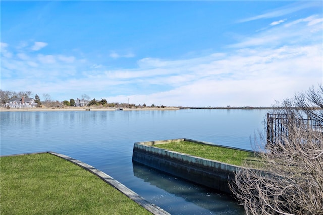 view of dock with a water view and a lawn