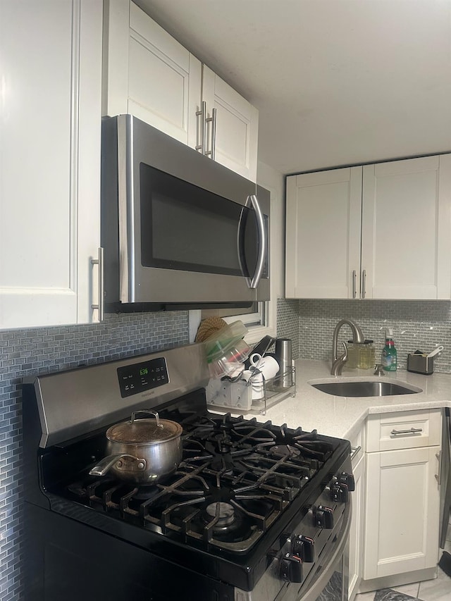 225-23 Murdock Ave, Queens Village, NY 11429 - kitchen featuring white cabinetry, appliances with stainless steel finishes, decorative backsplash, and a sink