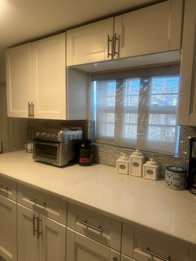225-23 Murdock Ave, Queens Village, NY 11429 - kitchen featuring a toaster, decorative backsplash, and white cabinets