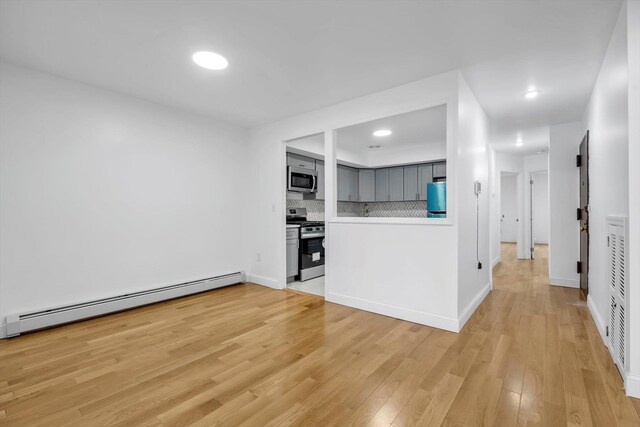 104-65 42nd Ave, Corona, NY 11368 - kitchen with light wood-style flooring, gray cabinetry, appliances with stainless steel finishes, tasteful backsplash, and baseboard heating