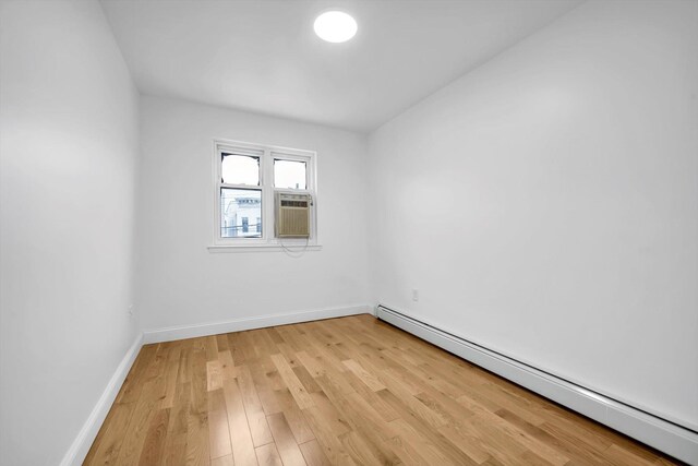 104-65 42nd Ave, Corona, NY 11368 - empty room featuring baseboard heating, baseboards, and light wood-style floors