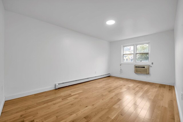 104-65 42nd Ave, Corona, NY 11368 - spare room featuring an AC wall unit, baseboards, light wood-type flooring, and baseboard heating