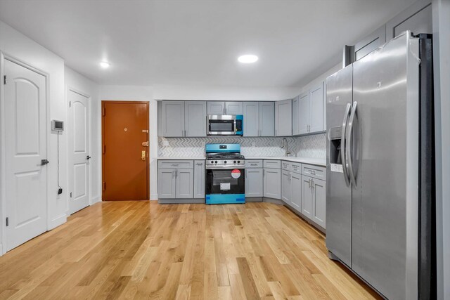 104-65 42nd Ave, Corona, NY 11368 - kitchen with tasteful backsplash, gray cabinets, appliances with stainless steel finishes, and light wood-type flooring