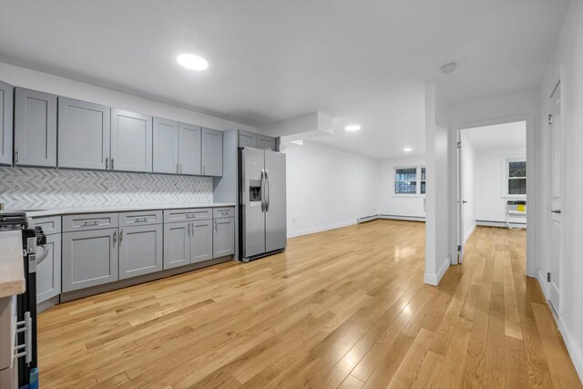 104-65 42nd Ave, Corona, NY 11368 - kitchen with gray cabinetry, backsplash, light wood-style floors, appliances with stainless steel finishes, and light countertops