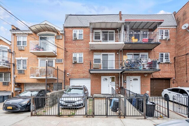 104-65 42nd Ave, Corona, NY 11368 - townhome / multi-family property with brick siding, a fenced front yard, driveway, and a garage