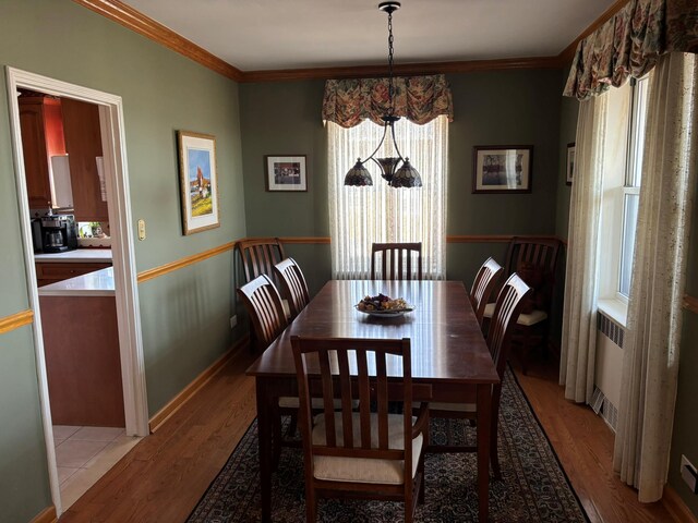 67-66 108th St Unit B64, Forest Hills, NY 11375 - dining room featuring light wood finished floors, crown molding, and baseboards