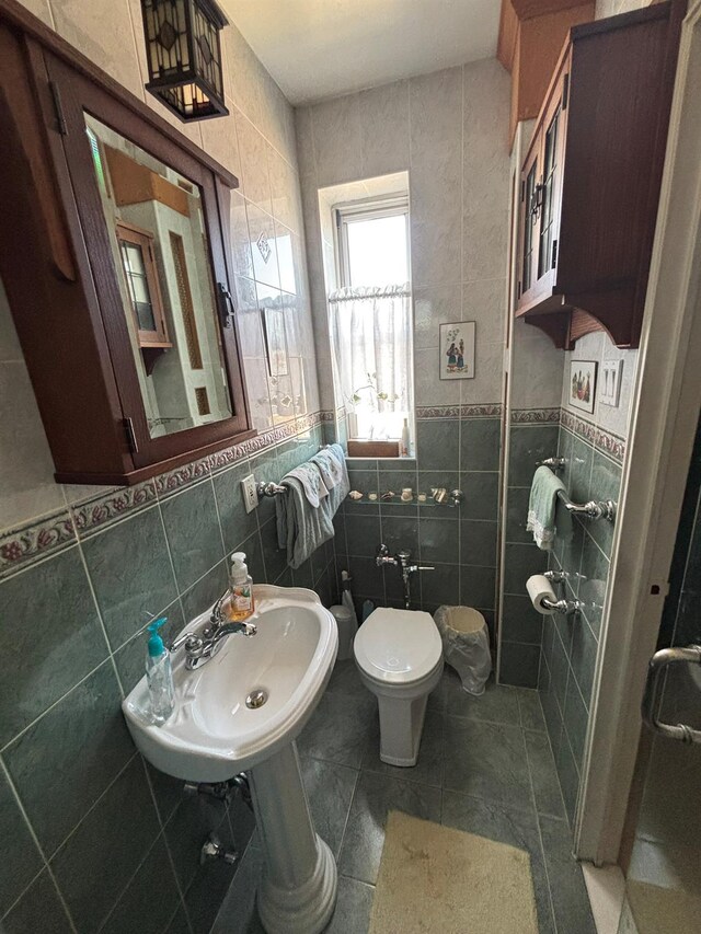 67-66 108th St Unit B64, Forest Hills, NY 11375 - bathroom featuring tile patterned floors, toilet, tile walls, and a sink
