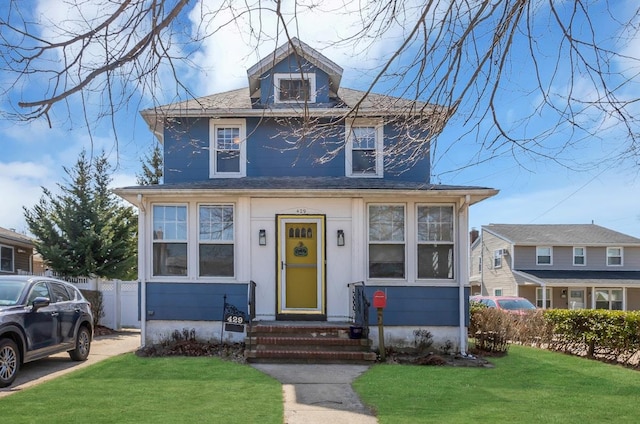 traditional style home with a front yard and fence