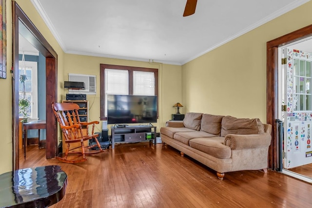 living room featuring wood-type flooring, a healthy amount of sunlight, and crown molding