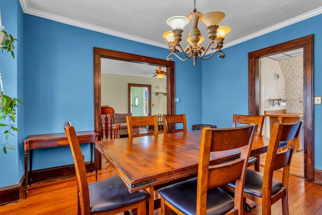 dining area with a chandelier, crown molding, and hardwood / wood-style floors