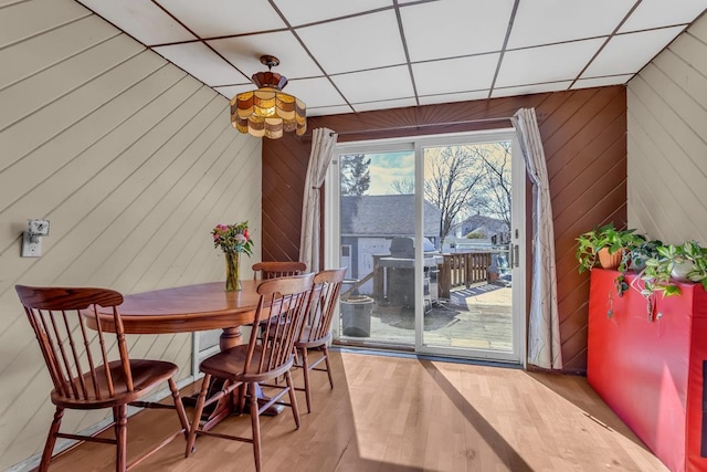 dining space featuring wooden walls and wood finished floors