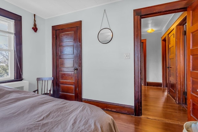 bedroom featuring wood finished floors and baseboards