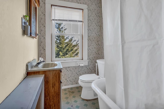 bathroom featuring wallpapered walls, baseboards, toilet, tile patterned floors, and vanity