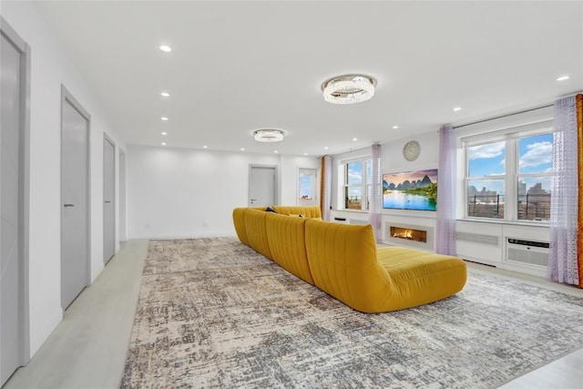 living room featuring radiator heating unit, recessed lighting, and a wall mounted air conditioner