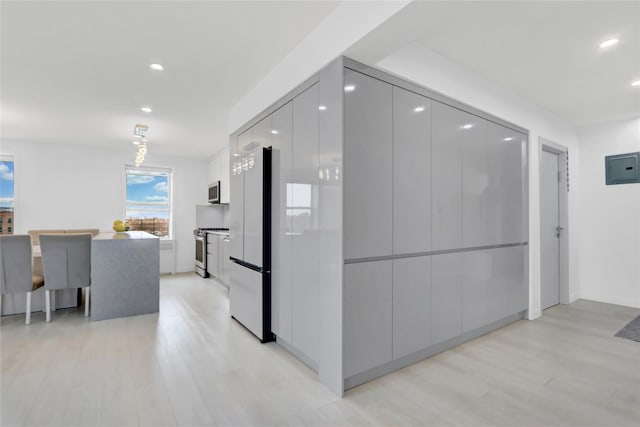 hallway featuring electric panel, recessed lighting, and light wood-type flooring