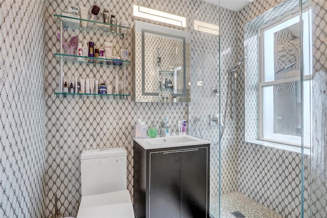 bathroom featuring tiled shower, toilet, and vanity