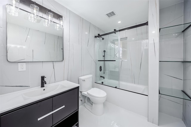 bathroom featuring visible vents, shower / bath combination with glass door, toilet, and vanity
