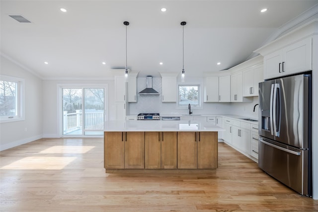 kitchen featuring a sink, stainless steel fridge with ice dispenser, range, wall chimney range hood, and visible vents