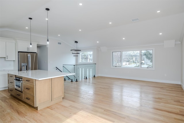 kitchen featuring light countertops, ornamental molding, and appliances with stainless steel finishes