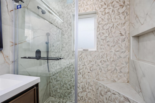 full bath featuring a marble finish shower, vanity, and wallpapered walls