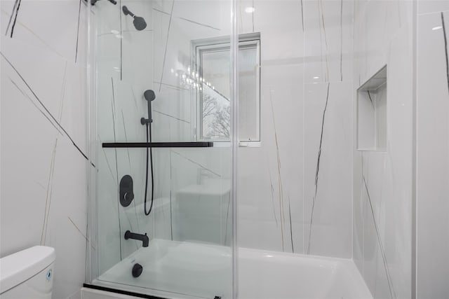 full bathroom featuring toilet and bath / shower combo with glass door