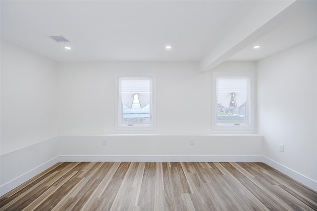 empty room with baseboards, visible vents, wood finished floors, and recessed lighting