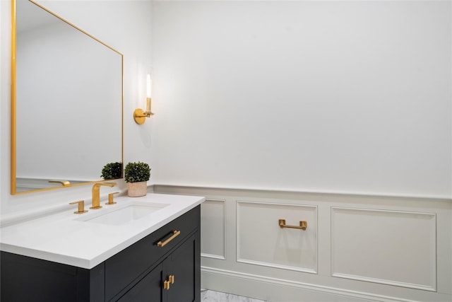 133 Spring Rd Unit 8, Huntington, NY 11743 - bathroom featuring a wainscoted wall, marble finish floor, vanity, and a decorative wall