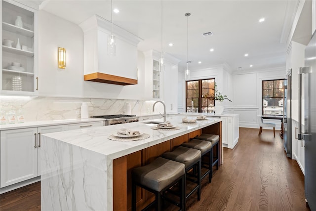 133 Spring Rd Unit 8, Huntington, NY 11743 - kitchen featuring a center island with sink, a sink, white cabinets, decorative backsplash, and dark wood-style flooring