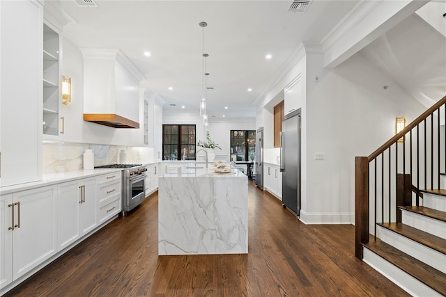 133 Spring Rd Unit 8, Huntington, NY 11743 - kitchen featuring dark wood-style floors, visible vents, an island with sink, white cabinets, and premium appliances