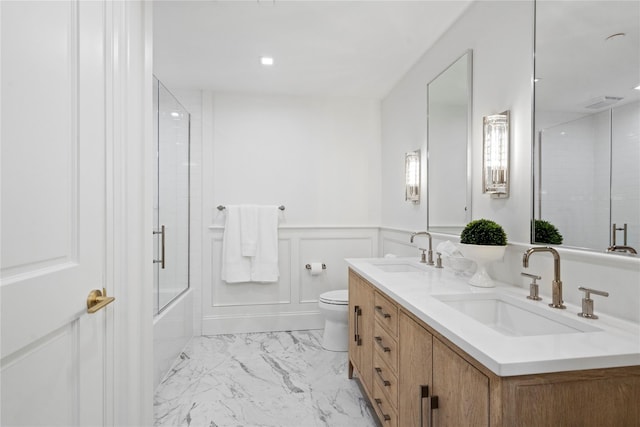 133 Spring Rd Unit 8, Huntington, NY 11743 - full bath featuring a sink, a wainscoted wall, toilet, and a decorative wall