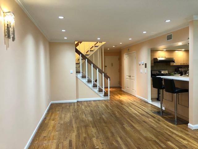 12-31 Robin Ln Unit 52L, Bayside, NY 11360 - kitchen with under cabinet range hood, wood finished floors, recessed lighting, baseboards, and crown molding