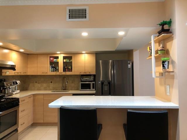 12-31 Robin Ln Unit 52L, Bayside, NY 11360 - kitchen with appliances with stainless steel finishes, a sink, a peninsula, decorative backsplash, and under cabinet range hood