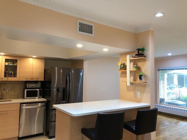12-31 Robin Ln Unit 52L, Bayside, NY 11360 - kitchen featuring stainless steel appliances, a sink, a peninsula, light countertops, and a kitchen breakfast bar