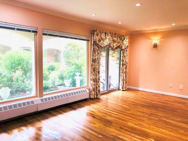 12-31 Robin Ln Unit 52L, Bayside, NY 11360 - spare room featuring a baseboard radiator, ornamental molding, wood finished floors, baseboards, and recessed lighting
