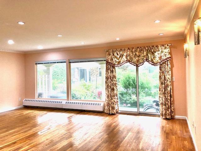 12-31 Robin Ln Unit 52L, Bayside, NY 11360 - spare room featuring ornamental molding, a baseboard radiator, wood finished floors, recessed lighting, and baseboards