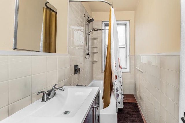 full bath featuring tile walls, vanity, and shower / bathtub combination with curtain
