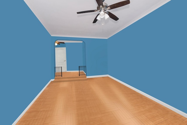 unfurnished room with baseboards, a ceiling fan, and crown molding