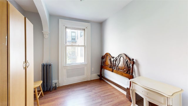 32-25 30th St, Long Island City, NY 11106 - doorway featuring radiator, light wood-style floors, and baseboards