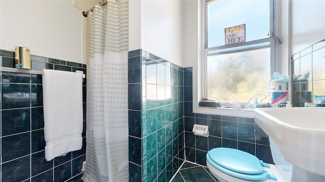 32-25 30th St, Long Island City, NY 11106 - bathroom with tile walls, toilet, wainscoting, and a sink
