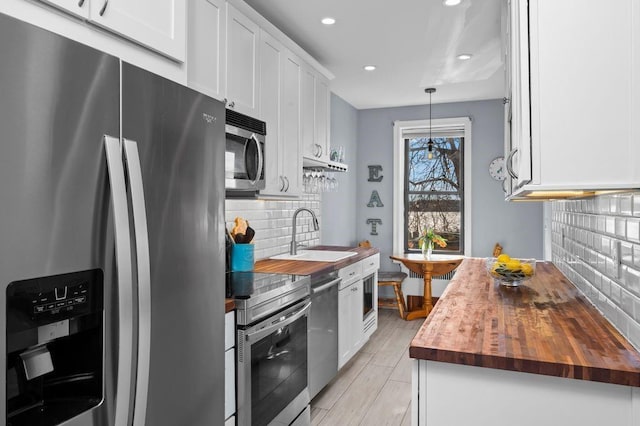 9701 Shore Rd Unit 1O, Brooklyn, NY 11209 - kitchen with tasteful backsplash, a sink, wooden counters, stainless steel appliances, and recessed lighting