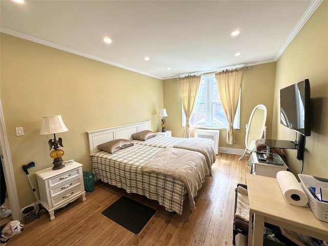 bedroom featuring radiator heating unit, recessed lighting, light wood-style floors, and ornamental molding